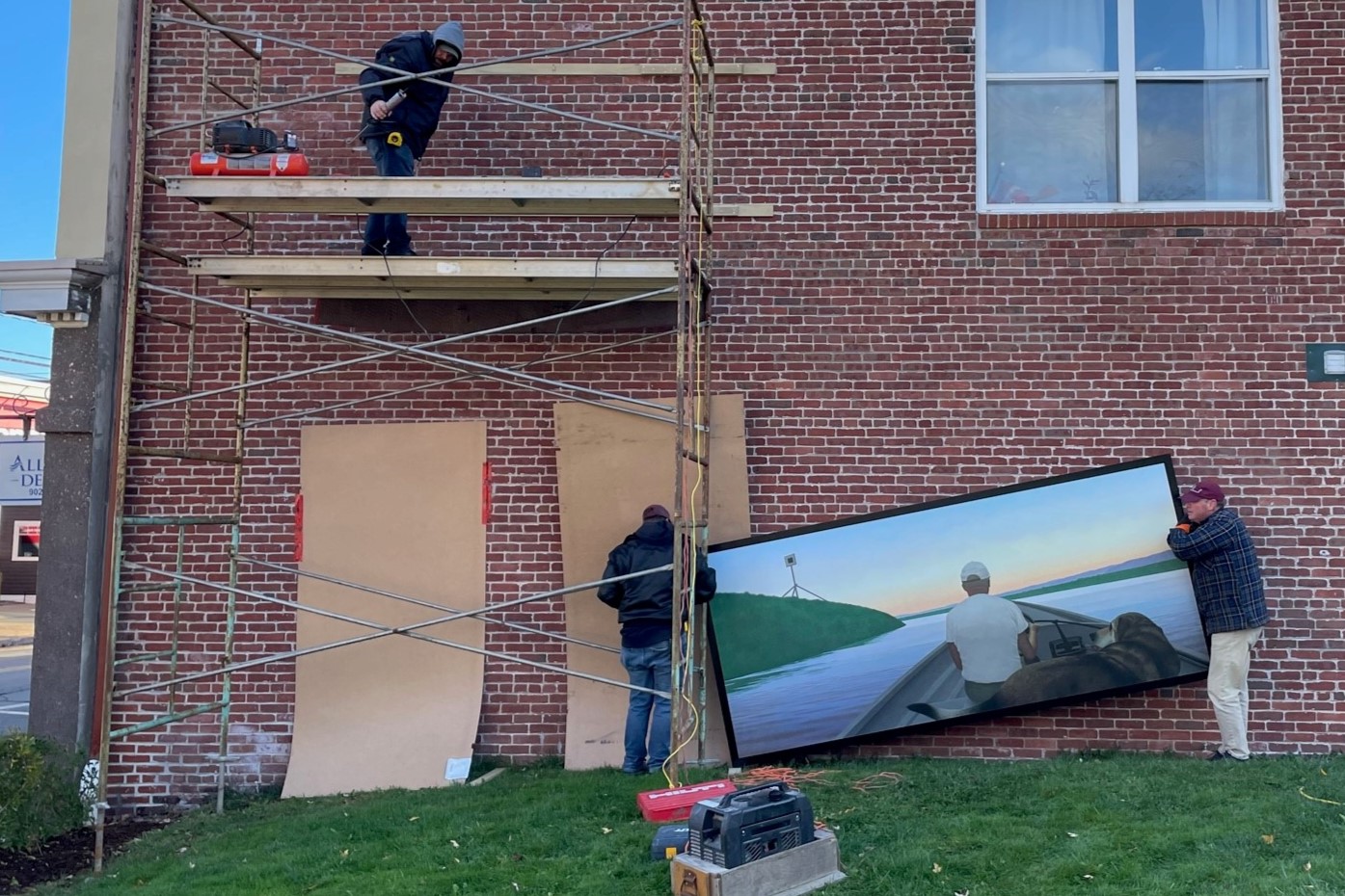 An Alex Colville reproduction is installed on the side of a building as work beings on a new outdoor gallery.