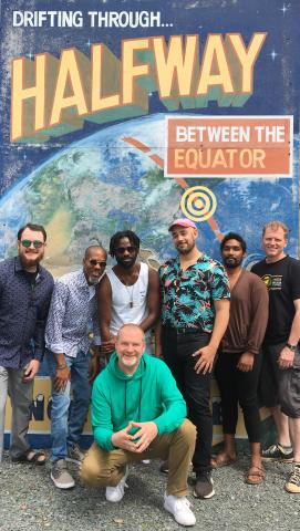 Andru Branch and Halfway Tree band stands in front of a mural that read: Drifting Through...Halfway Between the Equator